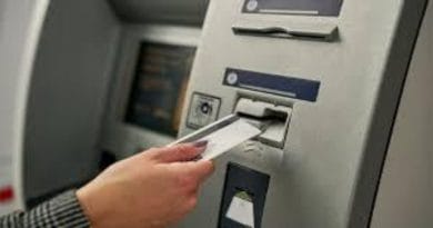 Close up of woman inserting credit card into ATM machine Marathi News