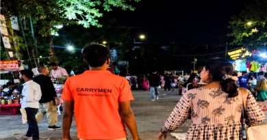 CarryMen shopping assistant helper walking with a customer in a busy night market.