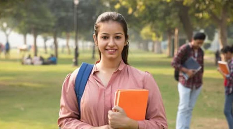 कॉलेज कॅम्पसमध्ये हातात पुस्तके घेऊन उभी असलेली भारतीय विद्यार्थिनी