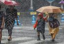 मुंबईत मुसळधार पाऊस सुरू असताना रस्त्यावरून छत्र्या आणि रेनकोट घालून चालणारे शाळकरी विद्यार्थी आणि नागरिक.
